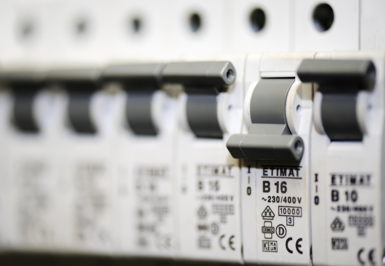 close-up row of white Etimat B16 and B10 circuit breakers rated at 230/400V in an electrical panel, the type of breakers that can trip and cut power to a home AC system.