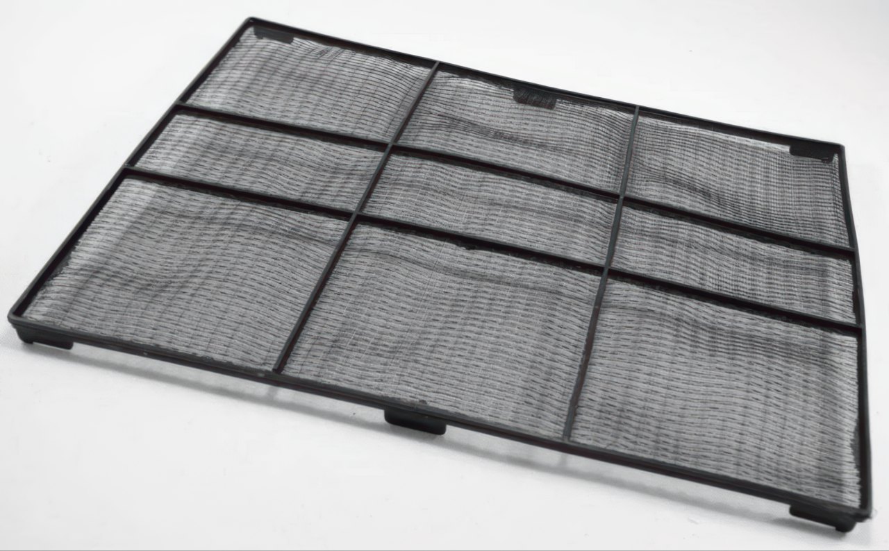 This professional photograph shows a black rectangular air filter with a fine mesh screen. The plastic frame is organized into a three by three grid and sits at an angle against a white background.