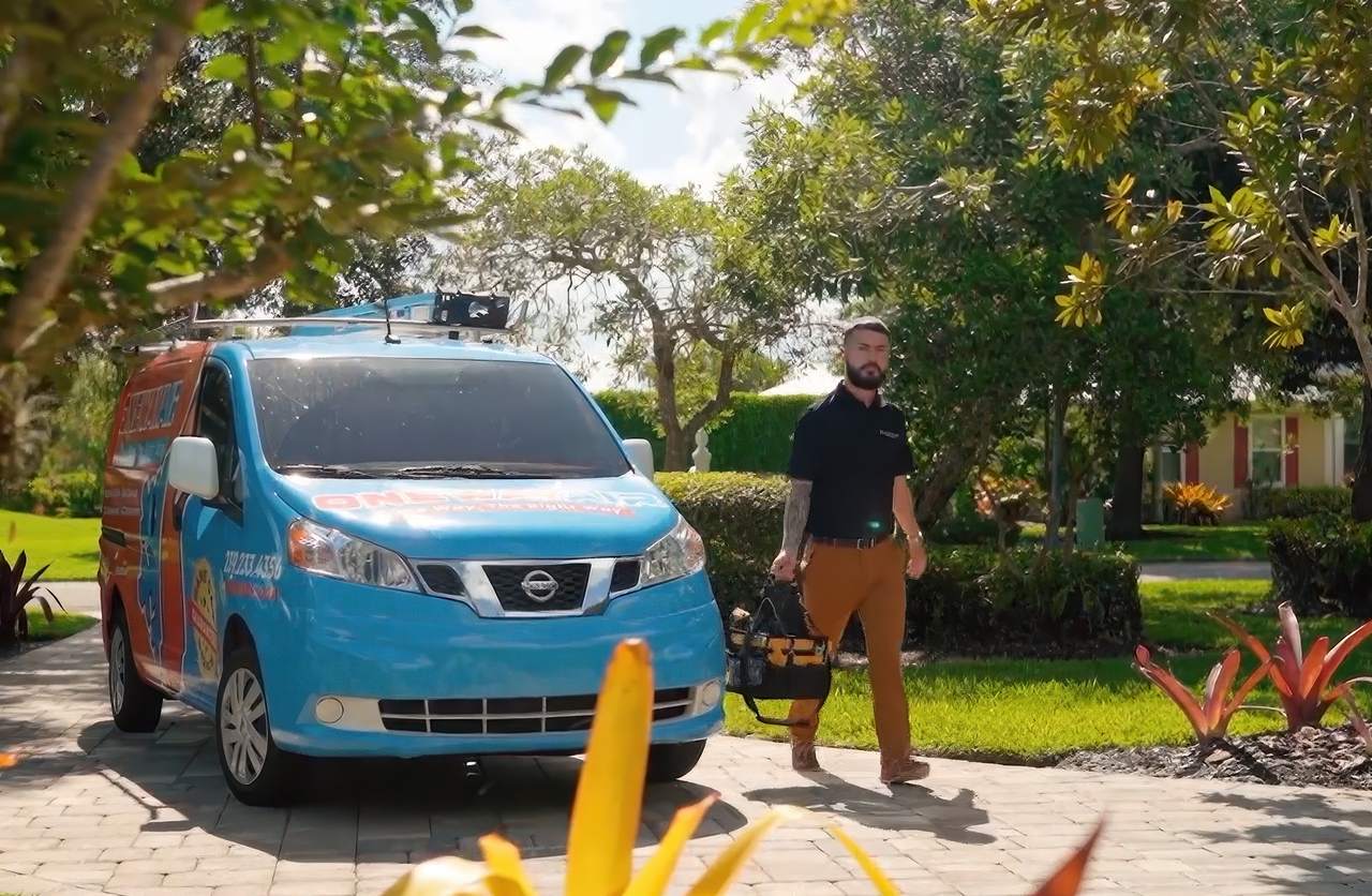 AC repair technician arriving at a Tampa home with service van and tool bag for same-day air conditioning repair.