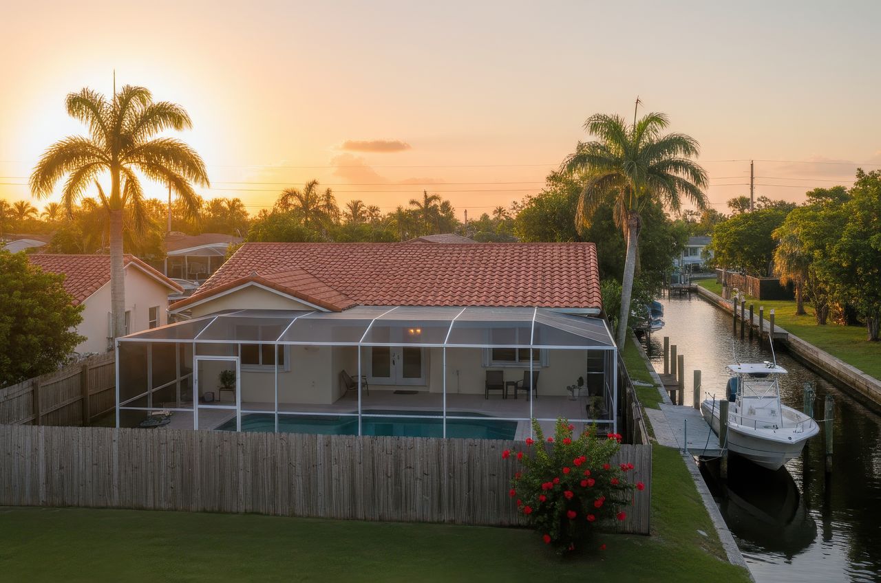 Coastal Florida home near a canal and palm trees, an environment where salty air can accelerate air conditioner corrosion and cause HVAC issues.